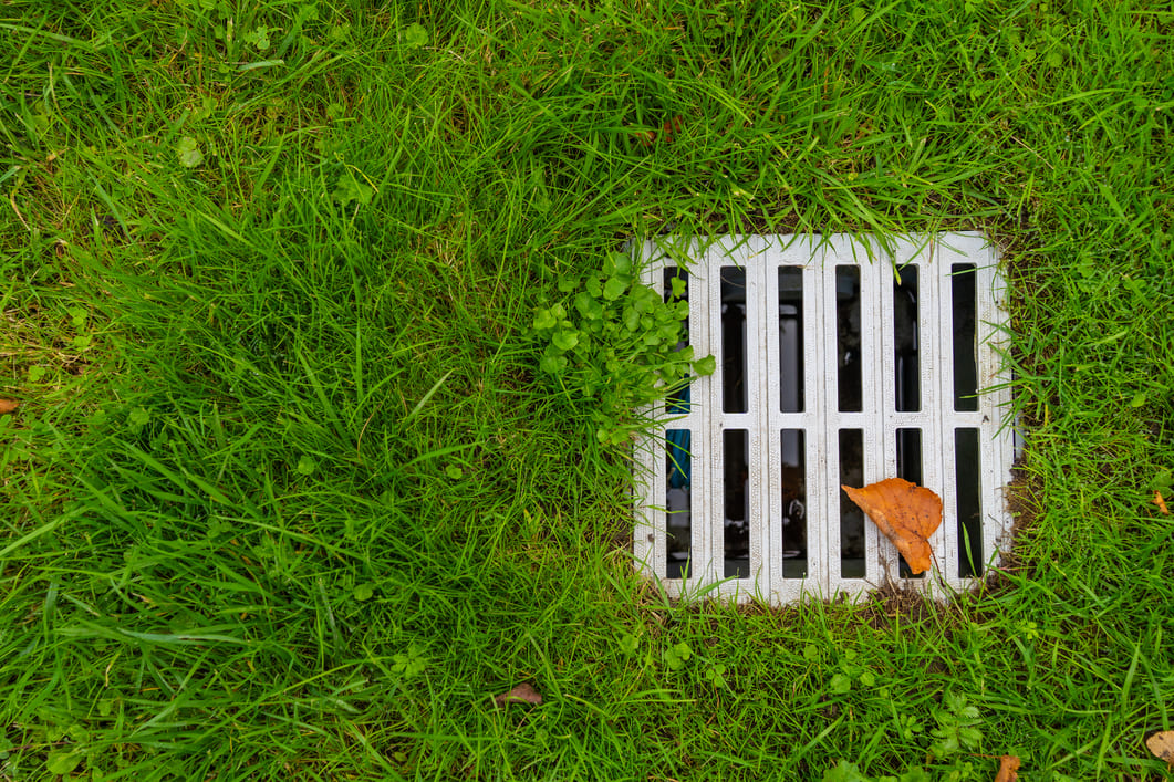 Web Stone Depot Landscaping Supplies South Lyon Michigan Drainage Solutions Yard Drain Metal yard drainage installed in a grassy lawn
