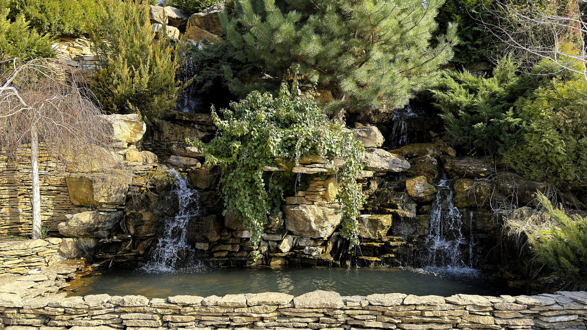 Natural stone waterfall creating a backyard water feature